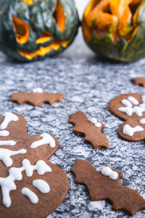 Halloween cookies and carved out pumpkins, on a gray background.の写真素材