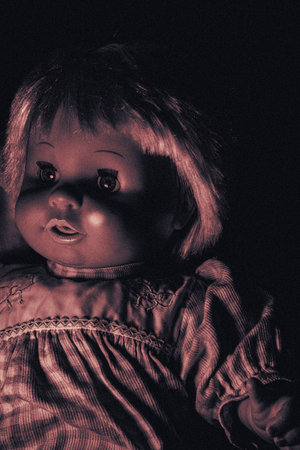 Creepy doll on a dark background. Halloween background.の写真素材