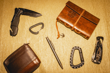 Black and leather EDC gear on a beige background.の写真素材