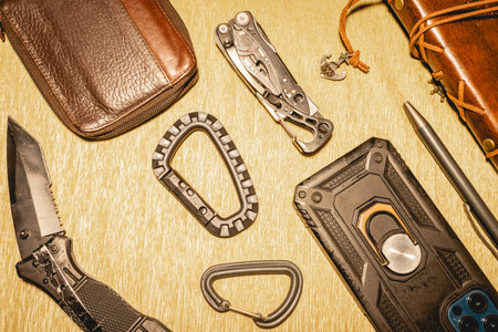 Black and leather EDC gear on a beige background.の写真素材