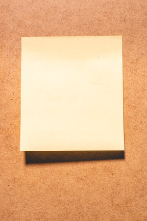 An empty sticky note on a brown background.の写真素材
