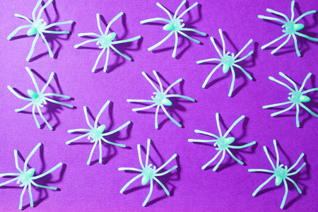 Fake spiders on a purple background. Halloween background.