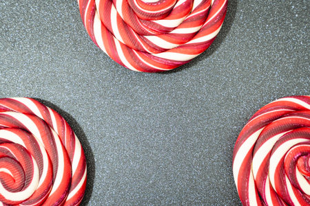 Christmas candy, red and white swirls, on a Gray background. Christmas overlay, background.
