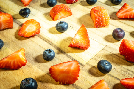 Strawberries and blueberries on a wooden cutting board. Healthy food.の写真素材