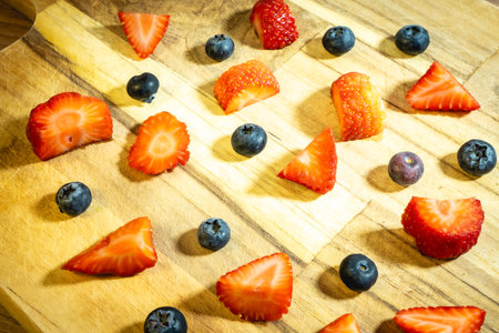 Strawberries and blueberries on a wooden cutting board. Healthy food.の写真素材