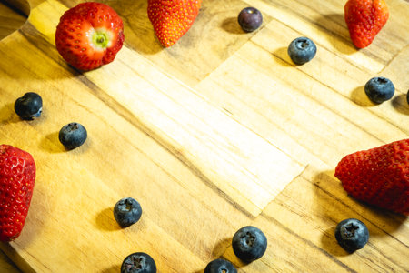 Strawberries and blueberries on a wooden cutting board. Healthy food.の写真素材