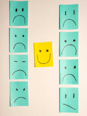 Sticky notes with smileys and one happy smiley. On a white background.の写真素材