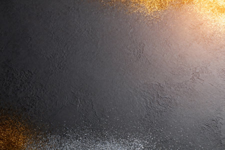 AI generated images. A structured dark gray background, with golden glitter and light. Background for Christmas or New Year.の素材