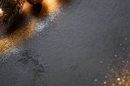 AI generated images. A structured dark gray background, with golden glitter and light. Background for Christmas or New Year.の素材