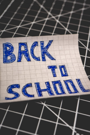 A Note with Back to School on it, on a Black background. Back To School background.