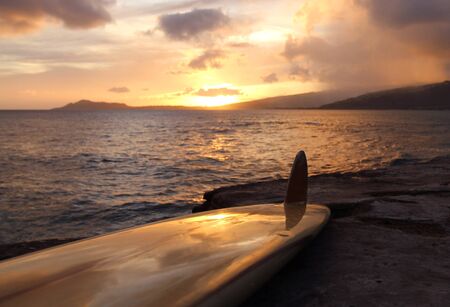 Vintage surfboard on rocky shoreline on Southern Oahu coast in Hawaiiの写真素材