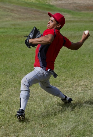 Baseball player throws a ball with strengthの写真素材