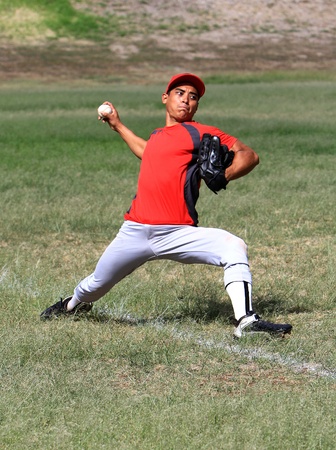 Baseball player throws a ball down the line with strengthの写真素材