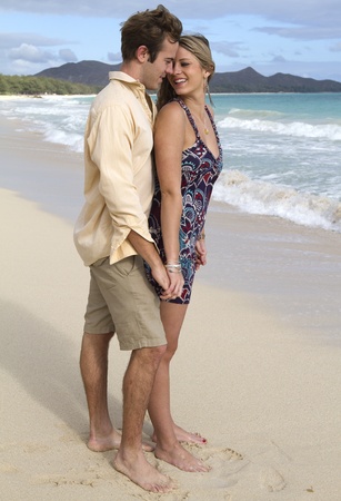 A beautiful young couple embrace on the shore in Hawaiiの写真素材