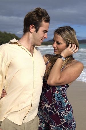 A beautiful young couple embrace on the shore in Hawaiiの写真素材