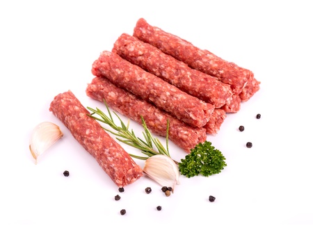Cevapcici - ready for the grill Delicious meat cevapcici with pepper, rosemary, parsley and garlic, isolated on whiteの写真素材