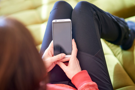 Woman holding blank smart phone screenの写真素材