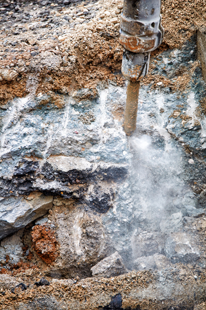 Close up of jackhammer - worker man using a jackhammer to drill into concreteの写真素材