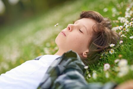 Happy calm young male relaxing in parkの写真素材
