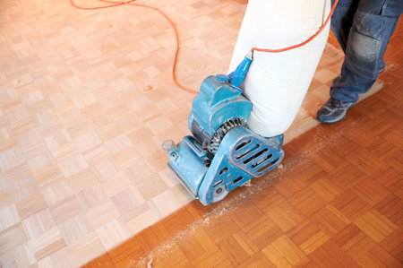 Worker polishing parquet floor with grinding machine - Hardwood floor restoringの写真素材