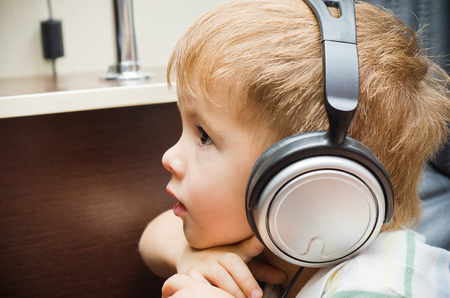 Portrait of a beautiful little boy in headphonesの写真素材