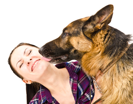 Portrait of a smiling young woman who licks German Shepherdの写真素材