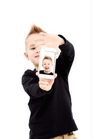 Portrait of attractive boy taking selfie on mobile phone, isolated on white backgroundの写真素材