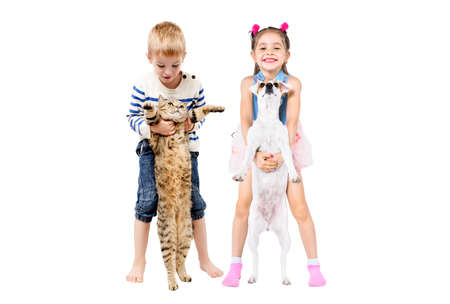 Cheerful cute kids standing together with pets isolated on white backgroundの写真素材