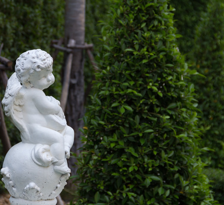Cupid statue on the white ball in the park.の写真素材