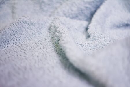 Closeup view of blue towel. Fluffy white backgroundの写真素材
