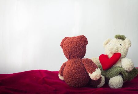 Bear and a heart shaped with white wall backgroundの写真素材