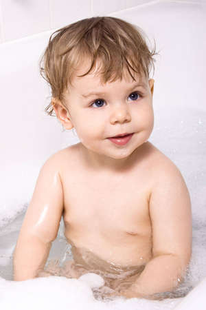 Baby girl sitting in the bath.の写真素材