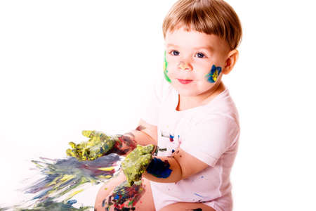 Child showing her palms colored with yellow paint.の写真素材