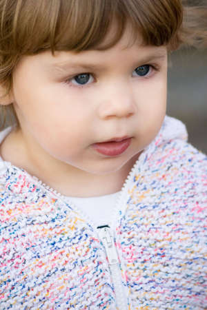 Portrait of 2 years old girl in white knitted jacket.の写真素材