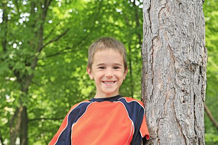 Boy Leaning up Against a Treeの写真素材