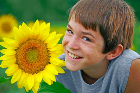 Boy Smiling with a Flowerの写真素材