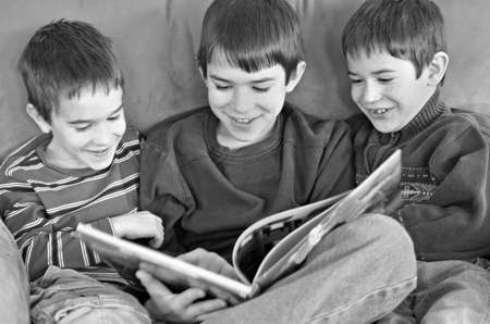 Three Boys Reading a Funny Book Togetherの写真素材