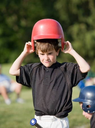 Little Boy Putting on Helmet Getting Ready to Hitの写真素材
