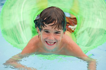 Little Boy Having Fun Floating in the Poolの写真素材