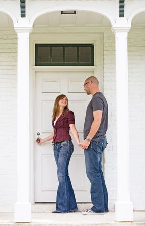 Happy Young Couple Entering Front Doorの写真素材