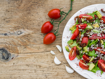 Fresh vegetable salad on a wooden deskの写真素材