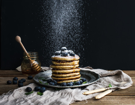 Pancake tower with fresh blueberry and mint on a rustic metal plate