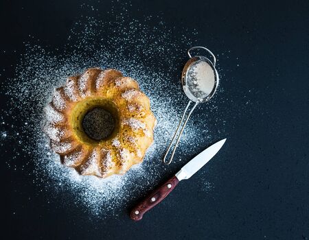 Moist orange bundt yogurt cake with sugar powder, dark grunge . Top viewの写真素材