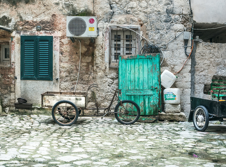 Kotor, Montenegro, Balkans, 24.01.2015. Typical paved yard with a bike-cart and lumber in the old town of Kotor, Montenegroのeditorial素材