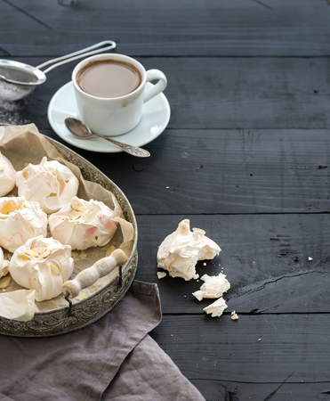 Almond meringues with cup of coffee on black rustic wooden table, top view, copy spaceの写真素材
