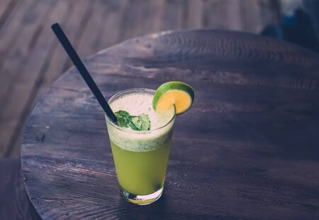 Fresh homemade lemonade with mint on dark wooden table in cafe, copy space