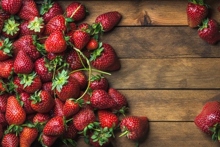 Summer fruit food frame. Strawberries over natural wooden background. Top view, copy spaceの写真素材