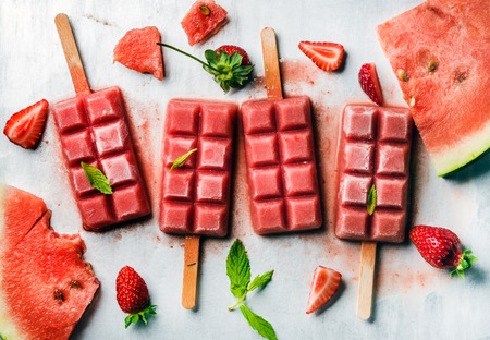 Strawberry watermelon ice cream popsicles with mint over steel tray background. Top viewの写真素材