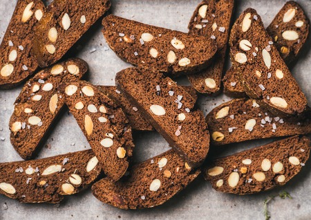 Close-up of dark chocolate and sea salt Biscotti with almonds on baking paper, top view, horizontal...