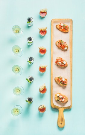 Various snacks, brushettas, gazpacho shots, desserts with berries and champagne on corporate event,...